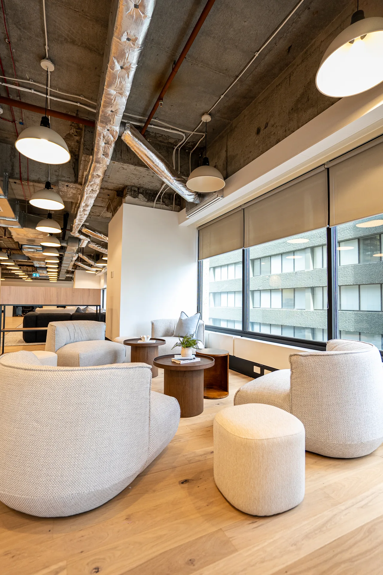 Breakout lounge with curved sofas and ottomans in a Sydney office fit-out